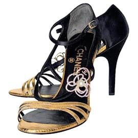 Sandali Chanel in pelle nera e oro con camelia