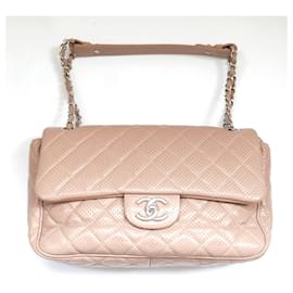 Bolso con solapa Classique de cuero perforado en beige de Chanel