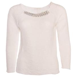 Maje, top blanco con cadena plateada.