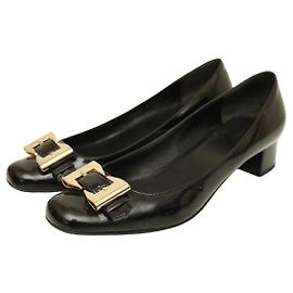 Gucci Schwarzes Lackleder mit goldfarbener Schleife und Schnalle und niedrigem Absatz. Schuhgröße 37.5