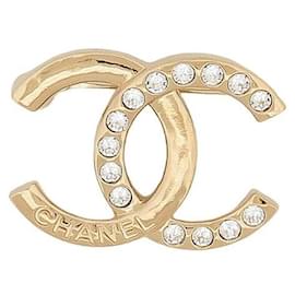 Broche Chanel en metal dorado champán y strass