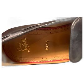 Mocassini Christian Louboutin in pelle nera con pompon e catena
