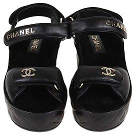 Sandali con tacco a cuneo in pelle trapuntata nera con logo Chanel e cinturino alla caviglia