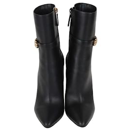 Botines de cuero negro con punta afilada y pin de seguridad Versace