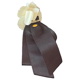 Spilla Chanel Camelia in tessuto crema e nastro di seta nero
