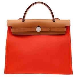 Il modello Herbag Zip 31 è una borsa tote che combina pelle di vitello Hunter e tela militare. Il corpo in tela offre leggerezza e un'eccezionale durata, e la combinazione di Orange Mecano e - Hermès