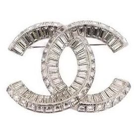 Spilla Chanel in metallo argentato e cristalli