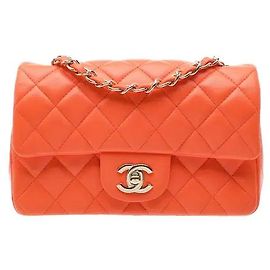 Die ikonische Classic Flap Bag New Mini von Chanel besticht durch eine leuchtend orange Farbe und ist aus hochwertigem Leder gefertigt, das eine hervorragende Formbeständigkeit bietet. Der vordere CC-Drehverschluss ist das Markenzeichen