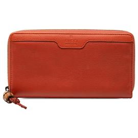 Cartera Gucci de piel naranja con cremallera y bambú