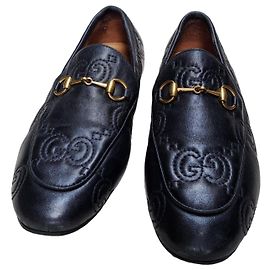 Mocassini Gucci in pelle nera con logo GG in rilievo
