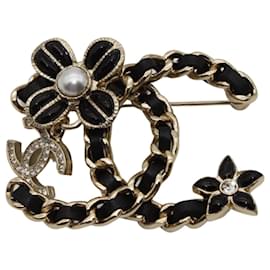 Spilla Chanel nera e oro con strass