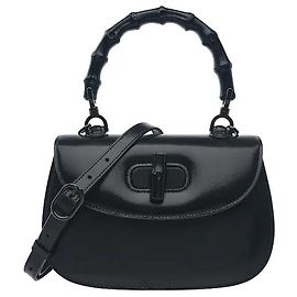 Gucci El asa de bambú natural, curvada con precisión mediante un proceso de calentamiento, presenta un veteado único en cada pieza, ofreciendo una rareza distintiva. Armoniza con el material suave para un estilo clásico pero