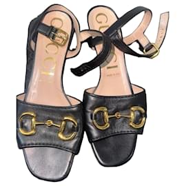 Gucci Sandalen aus schwarzem Leder mit goldenem Morsetto