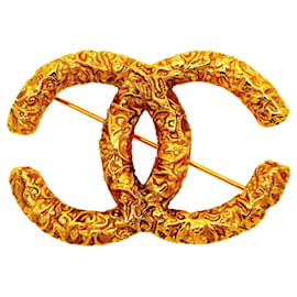 Spilla Chanel placcata oro con logo Coco e motivo lava