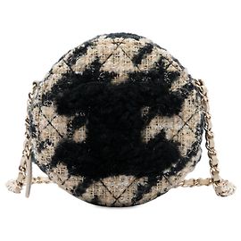 Clutch rotonda Chanel CC in tweed matelassé nero e shearling con tracolla a catena