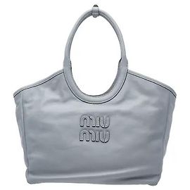 Miu Miu Un modello che armonizza materiale in pelle morbida e flessibile con un ornamento logo a lettere tridimensionali. La sua struttura a borsa tote, sottile e con un generoso spazio di archiviazione, contiene comodamente gli effetti personali, rendendo