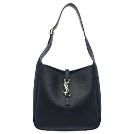 Saint Laurent La pelle Souple, morbida e flessibile, in una silhouette sottile e moderna, offre sia una lucentezza lussuosa che una vestibilità comoda. La pelle nera liscia si armonizza con il metallo YSL Cassandre in bronzo vintage sul davanti.