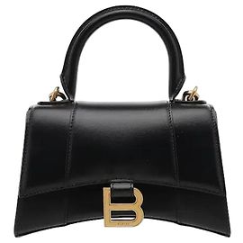 Balenciaga Una borsa a mano hourglass con manico superiore, caratterizzata da un fondo arcuato distintivo e una silhouette curva. Realizzata in materiale di pelle premium, vanta un'eccezionale mantenimento della forma, e l'ornamento con logo B in metallo su