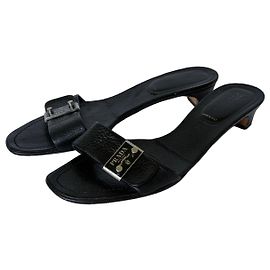 Sandalias slide de piel negra Prada con detalle de hebilla