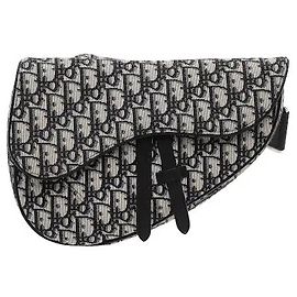 Christian Dior Un prodotto che applica l'iconica silhouette Saddle al jacquard Oblique firma del brand. Una chiusura a zip all'interno del lembo magnetico permette una conservazione sicura, ed è caratterizzato da un Dior
