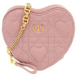 Christian Dior Un prodotto compatto che aggiunge l'iconica impuntura Cannage di Dior a una silhouette a forma di cuore. L'ornamento con la firma CD sul davanti e la catena in metallo aggiungono un tocco di eleganza, mentre la chiusura a zip permette di riporre i piccoli oggetti.
