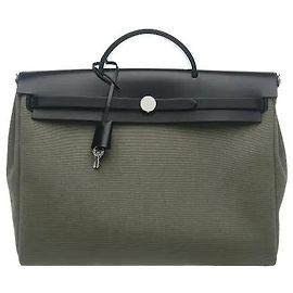 Hermès Una borsa che offre una sensibilità classica ma moderna attraverso l'armonia di un corpo in canvas robusto e rifiniture in pelle morbida sulla parte superiore. Il caratteristico dettaglio della chiusura a tracolla di Hermes e la silhouette flessibile si distinguono