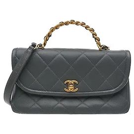 Un producto caracterizado por una silueta que añade un asa superior y una correa de cadena a un diseño acolchado clásico. El material de piel de cordero suave y el cierre de giro CC resaltan la elegancia distintiva de Chanel.
