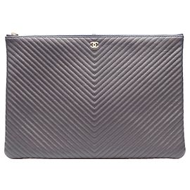 Borsa Clutch Chanel in pelle caviar blu navy con cuciture a V Chevron