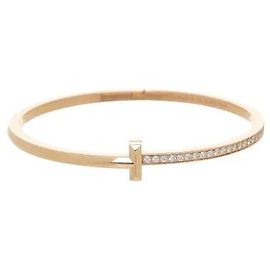 Tiffany & Co Un ángulo tridimensional y una silueta de brazalete contenida, que reinterpretan modernamente el icónico motivo T, completan un aire sofisticado. Diseñado con una estructura de bisagra precisa, permite una apertura suave,