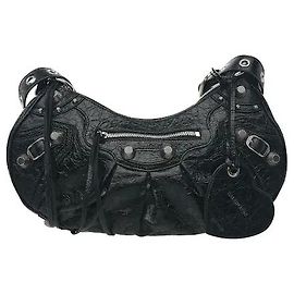 Balenciaga Vintage-geprägtes Leder harmoniert mit markanten Metallnieten, um einen trendigen Look zu vervollständigen. Die flexible, geschwungene Silhouette sorgt für eine hervorragende Passform, und der Reißverschluss schützt den Innenraum.