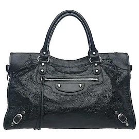 Balenciaga La pelle di agnello Arena, caratterizzata da distintive pieghe vintage, è impreziosita da iconici borchie metalliche e dettagli con fibbia per completare un sensuale stile borsa moto. Un generoso scomparto principale di medie dimensioni