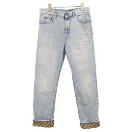Gucci Pantaloni in denim dritti con risvolto e logo GG