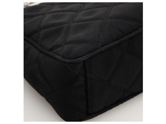 Uma mala de ombro que adiciona um padrão acolchoado sofisticado ao material de nylon icónico da Prada, revelando uma sensibilidade clássica mas moderna. O corpo de nylon, leve e resistente, é resistente a manchas do dia a dia. Preto - vista 6