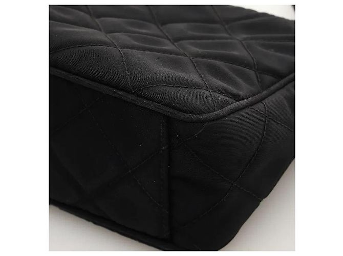 Uma mala de ombro que adiciona um padrão acolchoado sofisticado ao material de nylon icónico da Prada, revelando uma sensibilidade clássica mas moderna. O corpo de nylon, leve e resistente, é resistente a manchas do dia a dia. Preto - vista 7