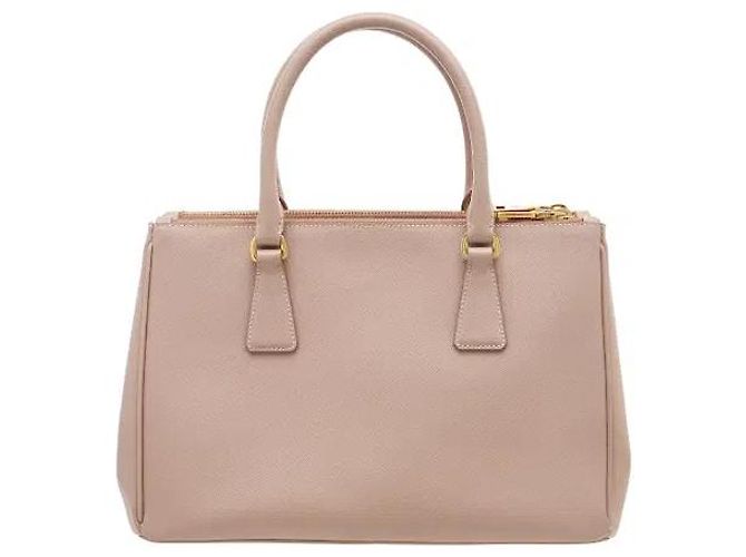 L'iconica pelle Saffiano di Prada, con il suo caratteristico motivo a croce, è resistente a graffi e macchie, mantenendo un aspetto pulito anche con l'uso quotidiano. La sua silhouette robusta... Rosa - vista 2