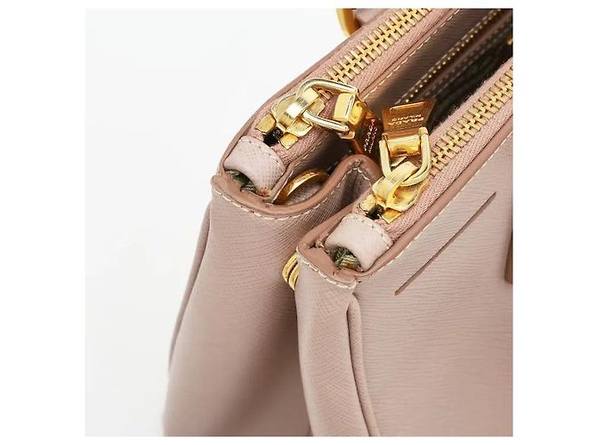 L'iconica pelle Saffiano di Prada, con il suo caratteristico motivo a croce, è resistente a graffi e macchie, mantenendo un aspetto pulito anche con l'uso quotidiano. La sua silhouette robusta... Rosa - vista 4