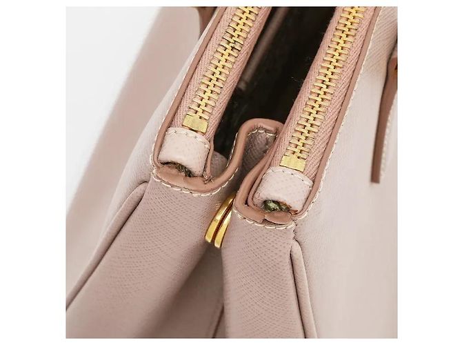 L'iconica pelle Saffiano di Prada, con il suo caratteristico motivo a croce, è resistente a graffi e macchie, mantenendo un aspetto pulito anche con l'uso quotidiano. La sua silhouette robusta... Rosa - vista 5