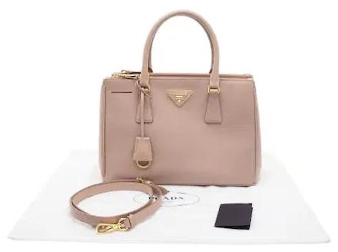 L'iconica pelle Saffiano di Prada, con il suo caratteristico motivo a croce, è resistente a graffi e macchie, mantenendo un aspetto pulito anche con l'uso quotidiano. La sua silhouette robusta... Rosa - vista 9