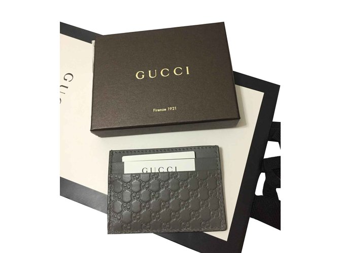 GUCCI MONOGRAM PHONE/CIGARETTE HOLDER, dark leather trims and flap snap  closure with iconic GG logo, fabric lining, 19cm x 12cm and a similar card  holder and a Piaget black leather wallet. (3)