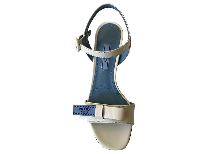 Prada Sandalen aus weißem Lackleder mit blauer Schleife