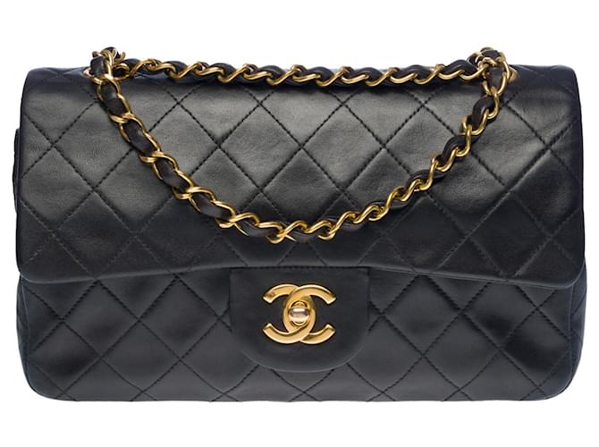 A cobiçada bolsa Chanel Timeless 23 cm com aba forrada em pele de cordeiro acolchoada preta, garniture en métal doré Preto Couro  ref.504264