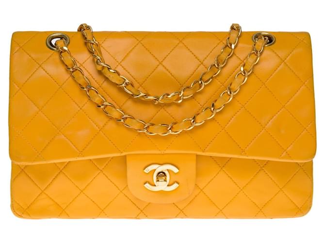 The coveted Chanel Timeless/Classique medium handbag 25cm in golden button yellow quilted leather, garniture en métal doré  ref.521130
