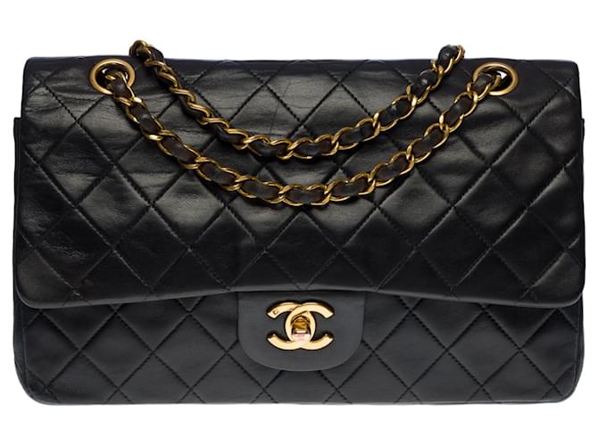 A cobiçada bolsa Chanel Timeless Medium 25 cm com aba forrada em couro preto, garniture en métal doré Pele de cordeiro  ref.552232