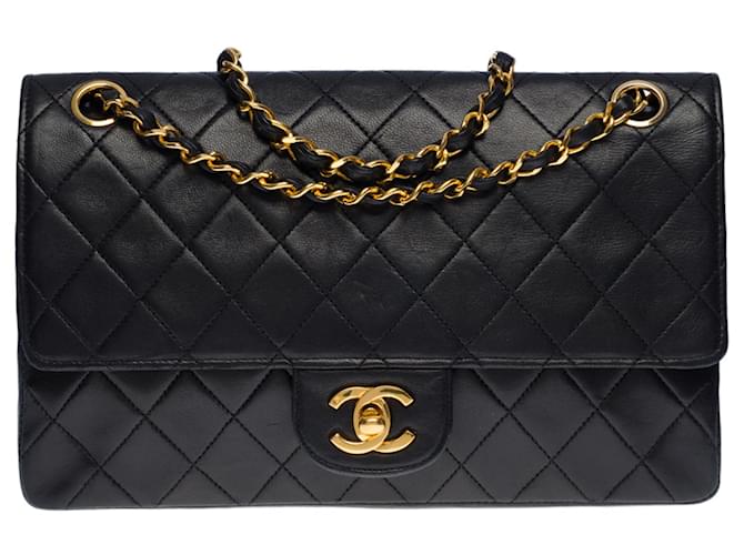 A cobiçada bolsa média Chanel Timeless/Classic 25 cm com aba forrada em pele de cordeiro acolchoada preta, garniture en métal doré Preto  ref.563456