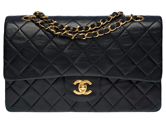 A cobiçada bolsa Chanel Timeless Medium 25 cm com aba forrada em couro preto acolchoado, garniture en métal doré Pele de cordeiro  ref.625830