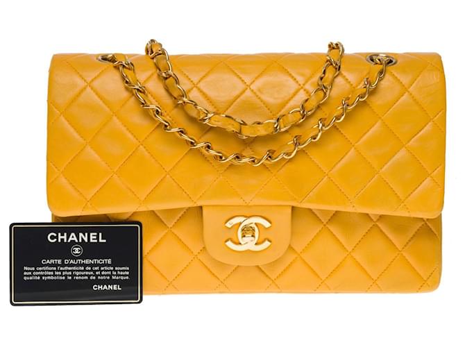 A icônica bolsa média “Must have” Chanel Timeless 25 cm com aba forrada em pele de cordeiro acolchoada amarelo ocre, Couro  ref.758835