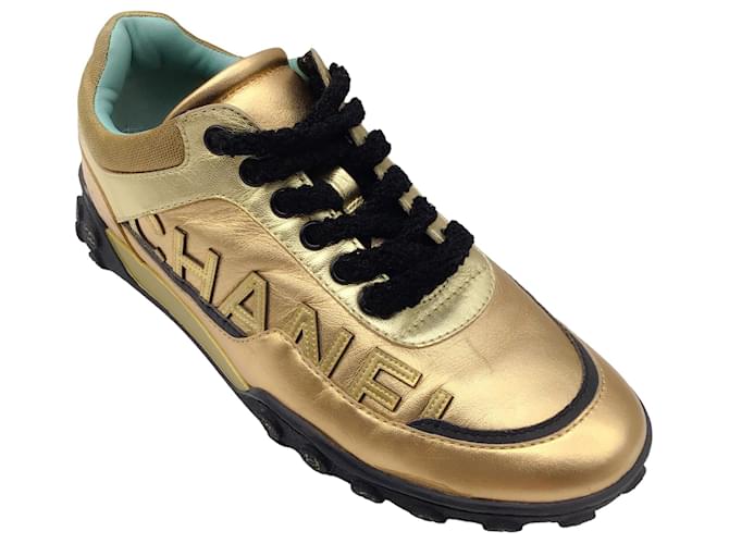 Autre Marque Chanel oro metallizzato / Sneakers basse in pelle con logo nero decorato D'oro  ref.1269294