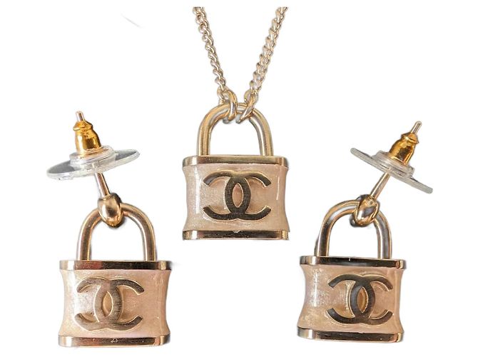 Chanel Conjunto de brincos e colar com cadeado iridescente rosa da marca CC B18P na caixa.
