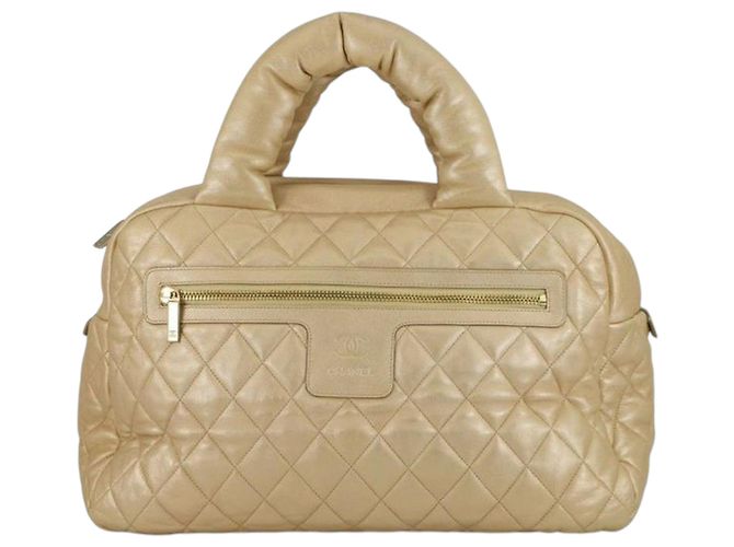 Bolsa de boliche Coco Cocoon em couro de cordeiro metálico acolchoado dourado da Chanel