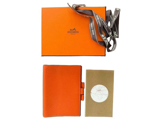 Capa de agenda de couro laranja Hermès com inserts de mapa-múndi